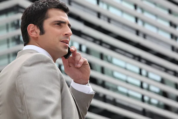 Young man talking on phone outdoors — Stock Photo, Image
