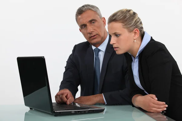 Geschäftsmann und Geschäftsfrau analysieren Daten auf ihrem Laptop — Stockfoto