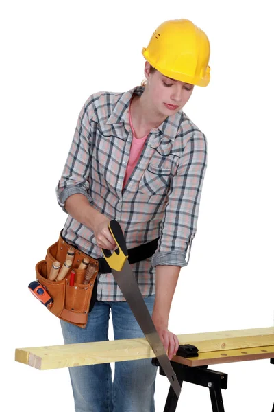 Woman sawing plank of wood — Stock Photo, Image