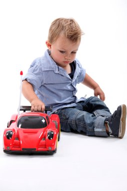 Young boy playing with a toy car clipart