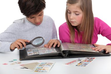 Kids watching a stamps album clipart