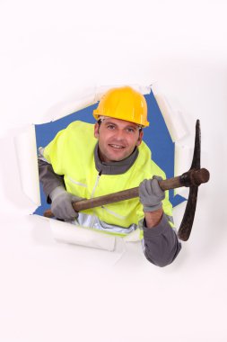 Man with pick-axe bursting through poster clipart