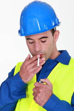 Handyman about to light a smoke. clipart