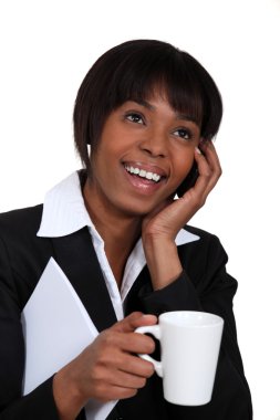 Businesswoman chatting on the phone with a hot drink clipart