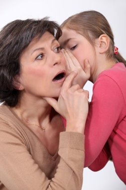 Little girl telling a secret to her mother clipart