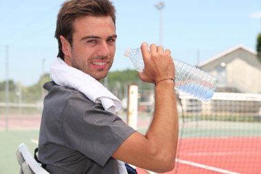 Tennis player drinking bottled water clipart