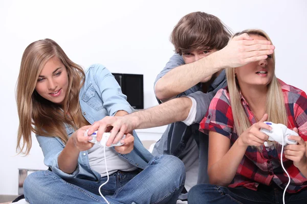 Três adolescentes sentados jogando videogames — Fotografia de Stock