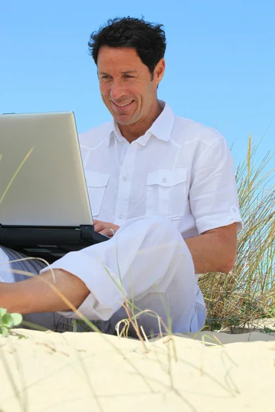 Homme heureux de travailler sur la plage . — Photo