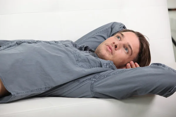 Мужчина лежит на диване — стоковое фото