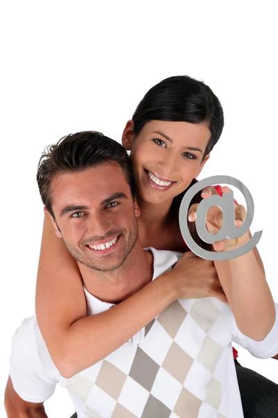 Casal segurando um símbolo em — Fotografia de Stock