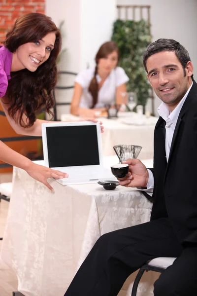 Couple looking at a blank computer screen in a restaurant — Stock Photo, Image