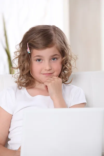 在一张沙发，笔记本电脑上的小女孩 — 图库照片