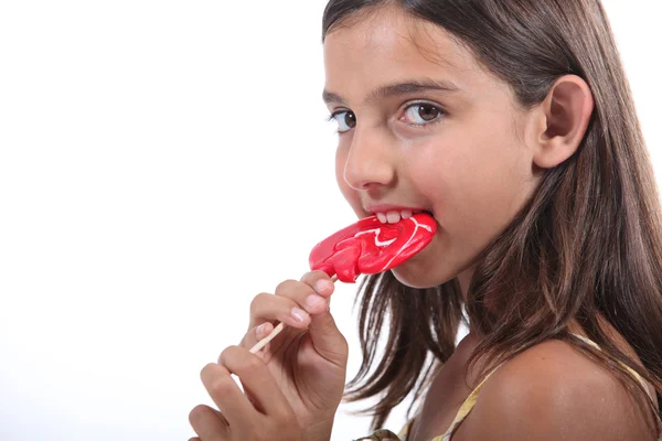 Young girl sucking on a lollipop — Stock Photo, Image