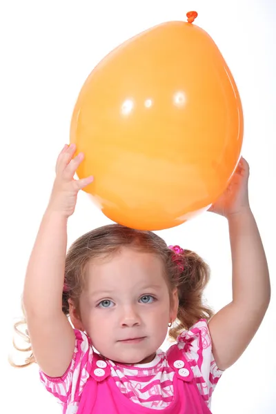 Una bambina bionda che gioca con un palloncino — Foto Stock