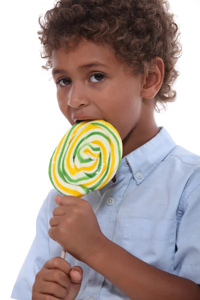Young boy licking a lollipop — Stock Photo, Image