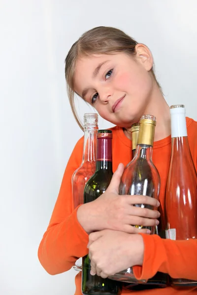 Young girl holding empty wine bottles — Stock Photo, Image