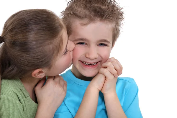 Маленького игривого мальчика целует маленькая девочка. — стоковое фото