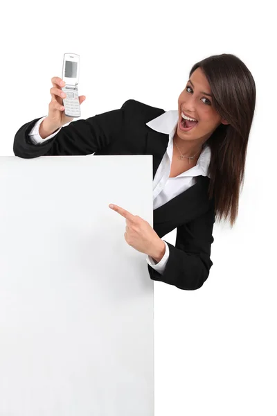 Businesswoman pointing at mobile phone — Stock Photo, Image