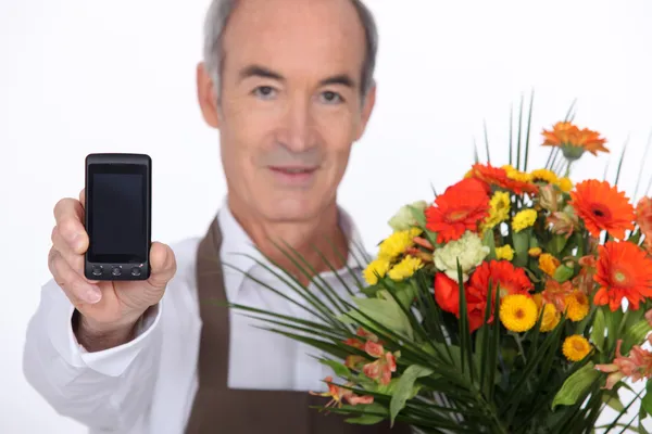 A florist showing a cell phone — Stock Photo, Image