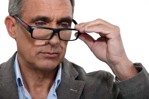 Knappe volwassen man met verlaagde bril — Stockfoto