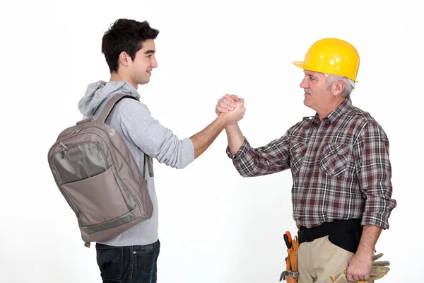 Craftsman and apprentice shaking hands — Stock Photo, Image