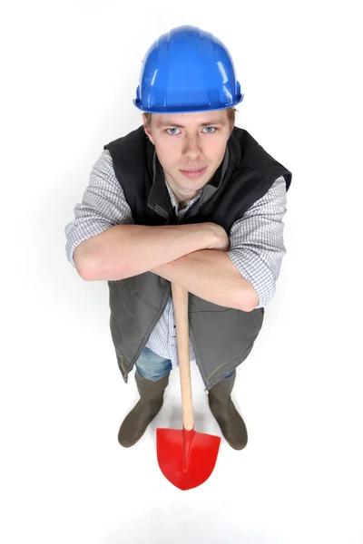 Een mannelijke bouwvakker met een schop. — Stockfoto