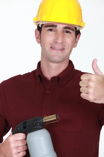 Craftsman holding a welding torch and making thumbs up sign — Stock Photo, Image