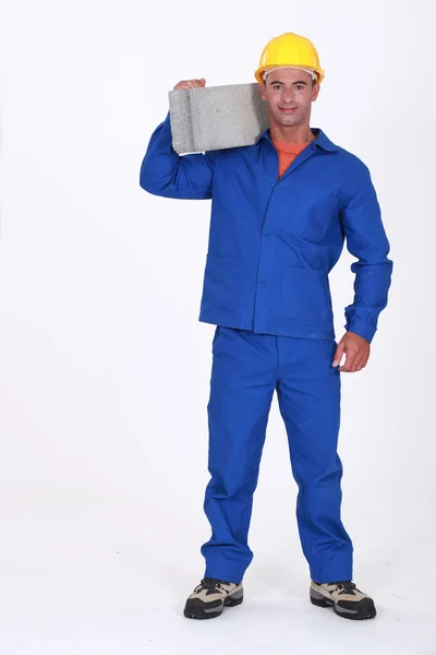 Builder carrying a concrete block — Stock Photo, Image