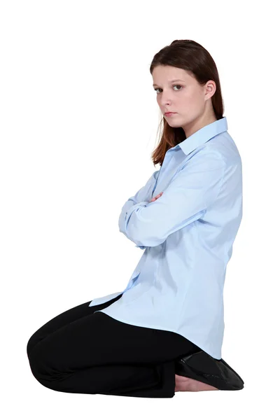 Woman kneeling down cross-armed looking sulky — Stock Photo, Image