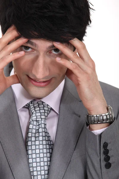 Businessman with hands to forehead facing pressure — Stock Photo, Image