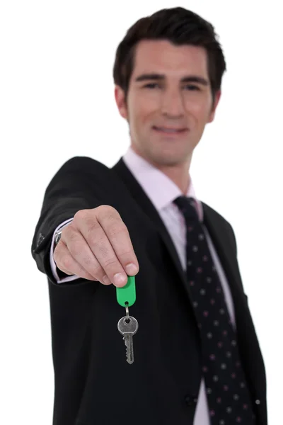 Агент по недвижимости свисает с ключами от дома — стоковое фото