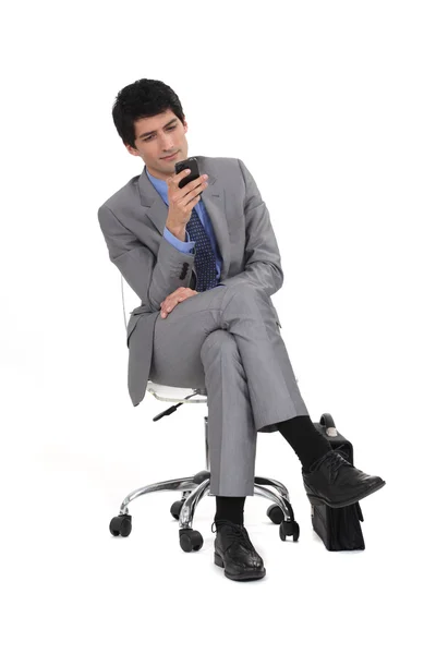 Mladý muž v obleku textovou zprávu — Stock fotografie