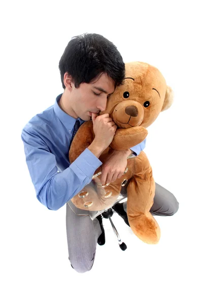 Um homem de negócios abraçando um urso de pelúcia . — Fotografia de Stock