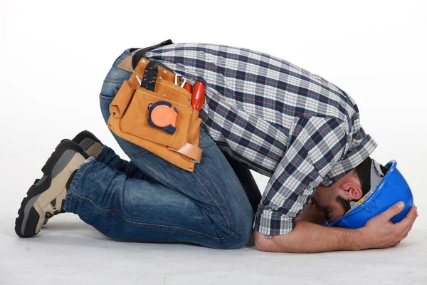 Construction worker curled up on the floor — Stok fotoğraf