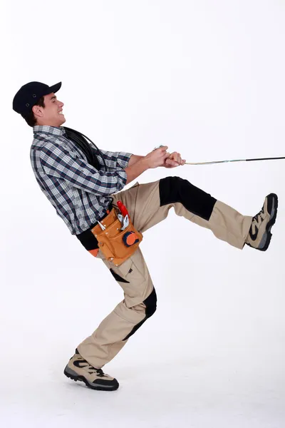 Handyman puxando uma corda — Fotografia de Stock