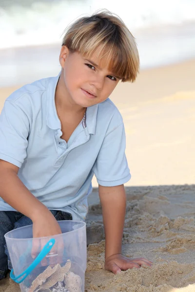 Mladý chlapec hraje na písečné pláži — Stock fotografie