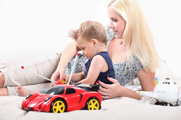 Mor och son leker med en leksaksbil — Stockfoto