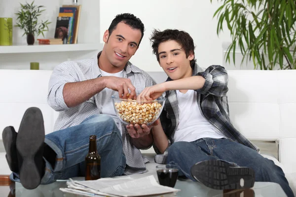 Pai e filho desfrutando de uma noite de cinema juntos — Fotografia de Stock
