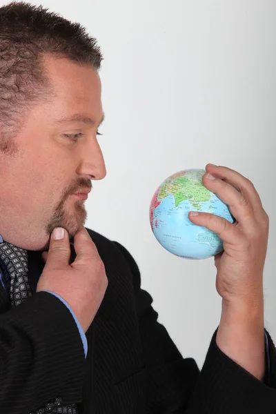 Homme d'affaires tenant un globe — Photo