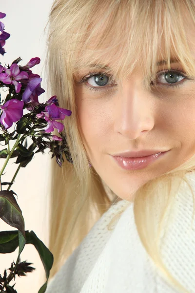 Eine Frau mit lila Blüten — Stockfoto