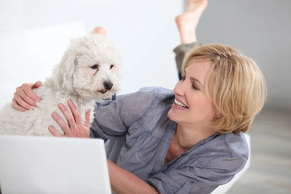 Γυναίκα που είναι χαμογελώντας με σκύλο και φορητό υπολογιστή — Φωτογραφία Αρχείου