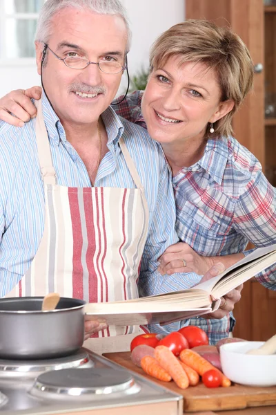 Ehemann schaut sich Kochbuch an — Stockfoto
