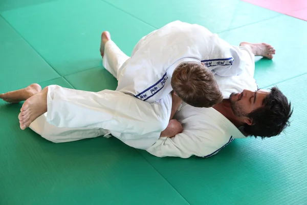Judo utövare i tag på matta — Stockfoto