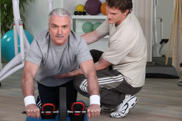 Mature man training with fitness coach — Stock Photo, Image