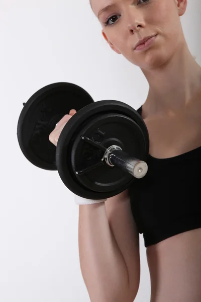A young woman lifting a dumbbell — Stock Photo, Image