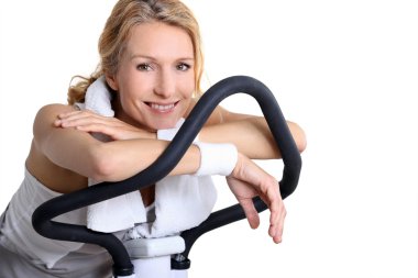 Portrait of a woman on exercise bike clipart