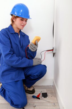Female electrician using a voltmeter clipart