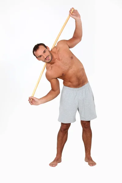 Hombre haciendo ejercicio con un palo de madera —  Fotos de Stock
