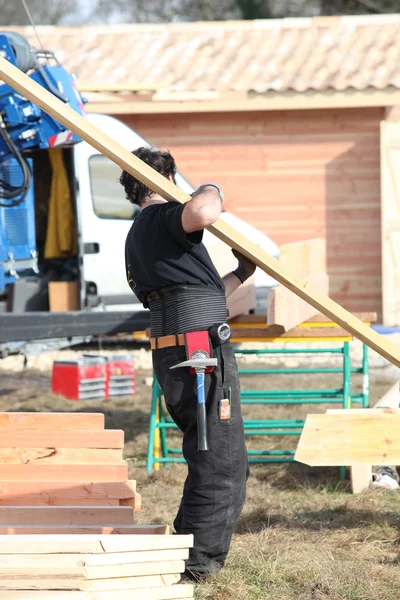 Carpenter holding planks — Stock Photo, Image