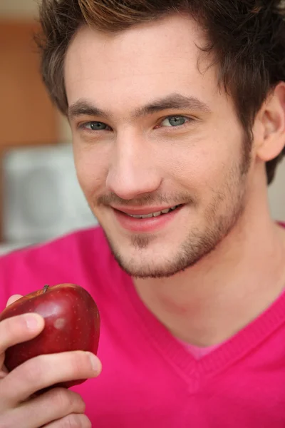 Ung man med ett rött äpple — Stockfoto